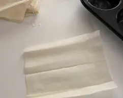 Step Mientras se hacen los champiñones, cortamos un paquete de masa filo en trozos. Yo he cortado cada lámina en 6 partes, he cortado todo el paquete a la vez, la masa filo es muy fina y fácil de cortar. illustration