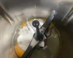 Step <p>Coloca la mariposa en las cuchillas . </p><p>Añade el huevo ,las llemas y la azucar y bate 4 min/vel 3,5</p> illustration