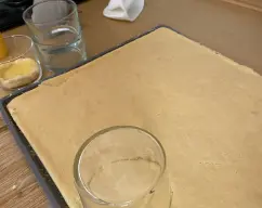 Step <p>Corte con un molde, en mi caso un vaso de los que voy a usar para hacer las raciones, empapé el bizcocho en zumo sin llegar a que se rompa. Extienda un poco de la crema y coloque encima otro trozo de bizcocho empapado. Termine con crema de mascarpone, cacao en polvo y ralladura de naranja para decorar. Repetir con todos los vasitos que salgan.</p> illustration